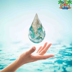 hand holding a large water droplet